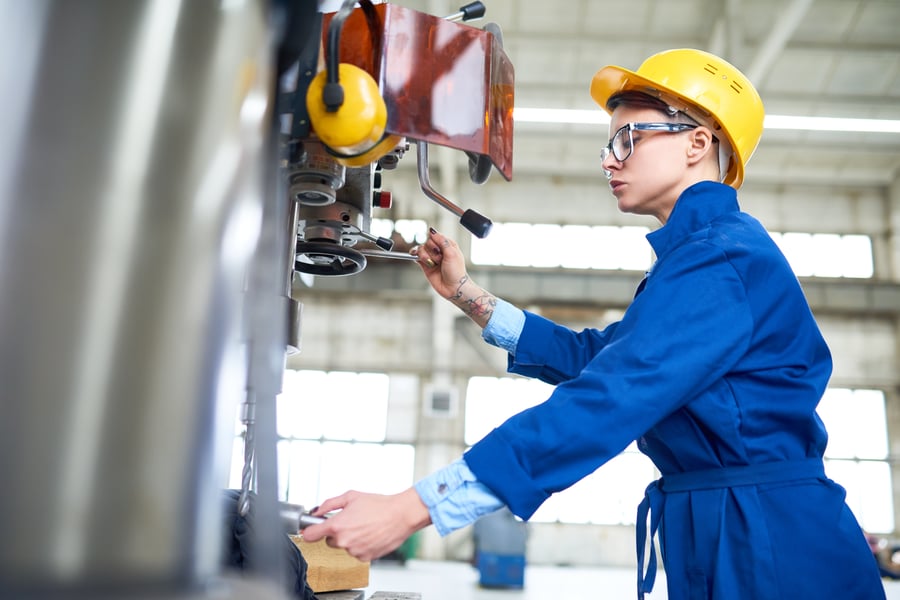 Manufacturing worker using a machine on the factory floor