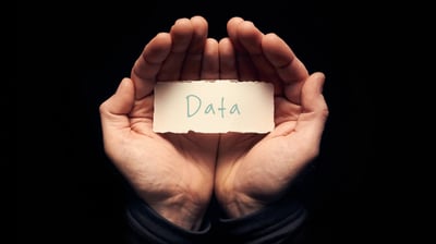 Hands holding a piece of paper that says Data