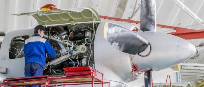 Aviation Engineer Repairing Jet Engines in Aircraft Hangar