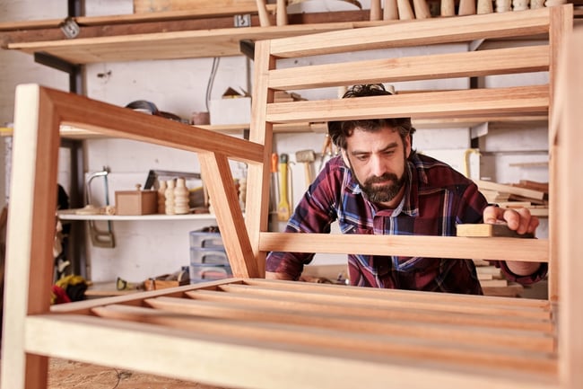 American Furniture Craftsman Touches Up the Finish on Wood Chair